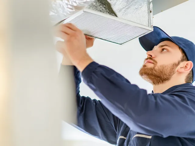 HVAC specialist installing an air purifier in a modern home interior